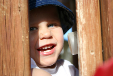 Alex playing peek-a-boo at the playground